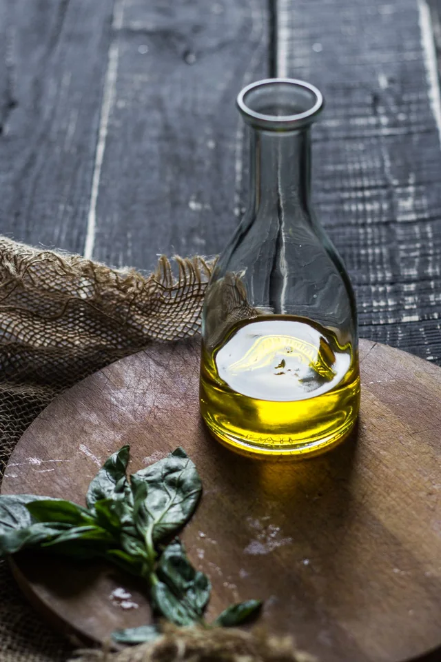 Aceite de oliva en una botella de cristal sobre una tabla de cocina