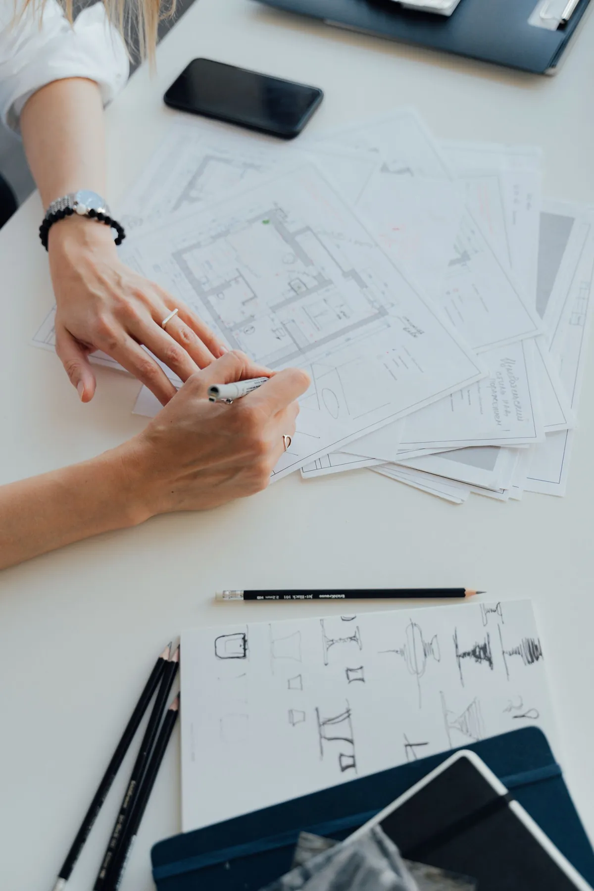 Manos revisando y anotando un plano de proyecto