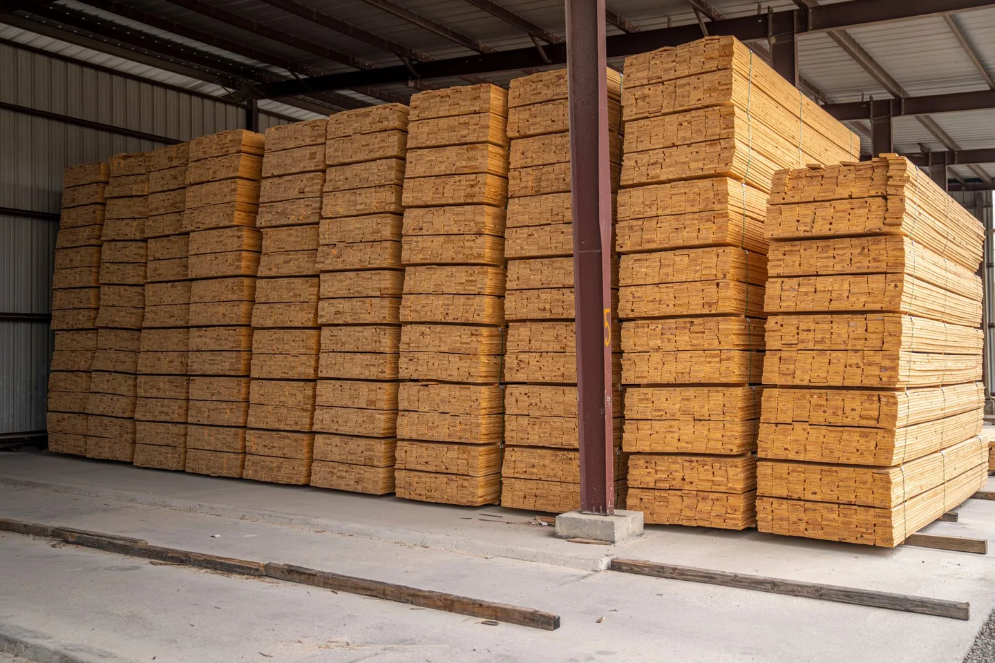 Tablones de madera clasificados y apilados en un almacén industrial
