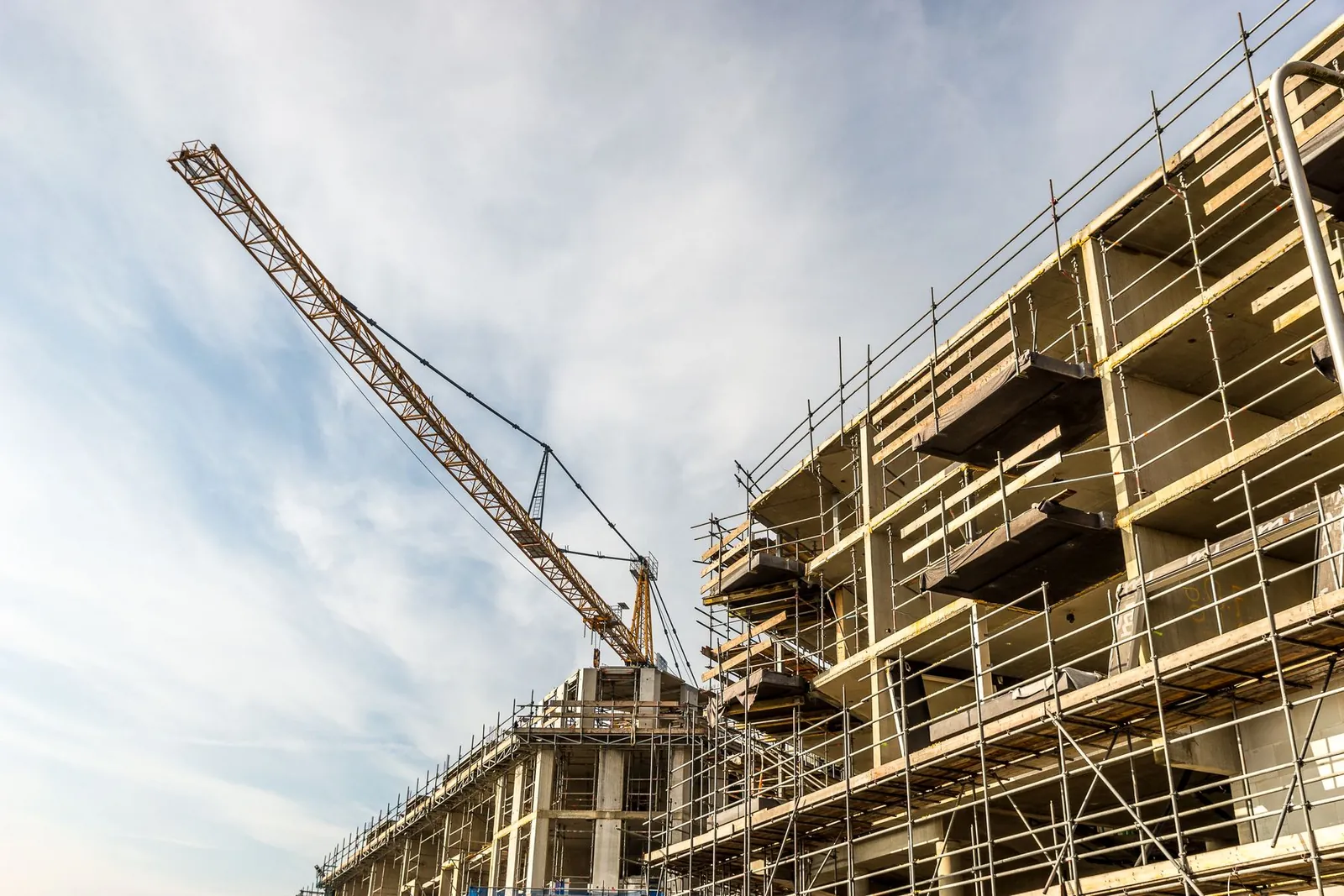 Edificio en construcción con andamios y grúa