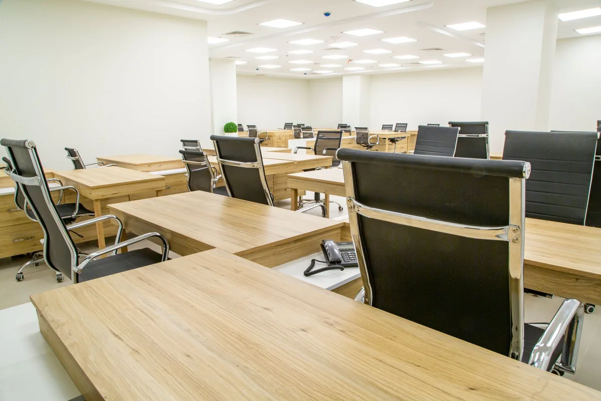 Interior de oficinas con mesas de trabajo y sillas