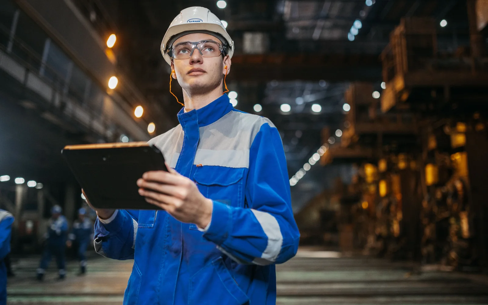 Ingeniero utilizando una tableta para revisar una planta industrial