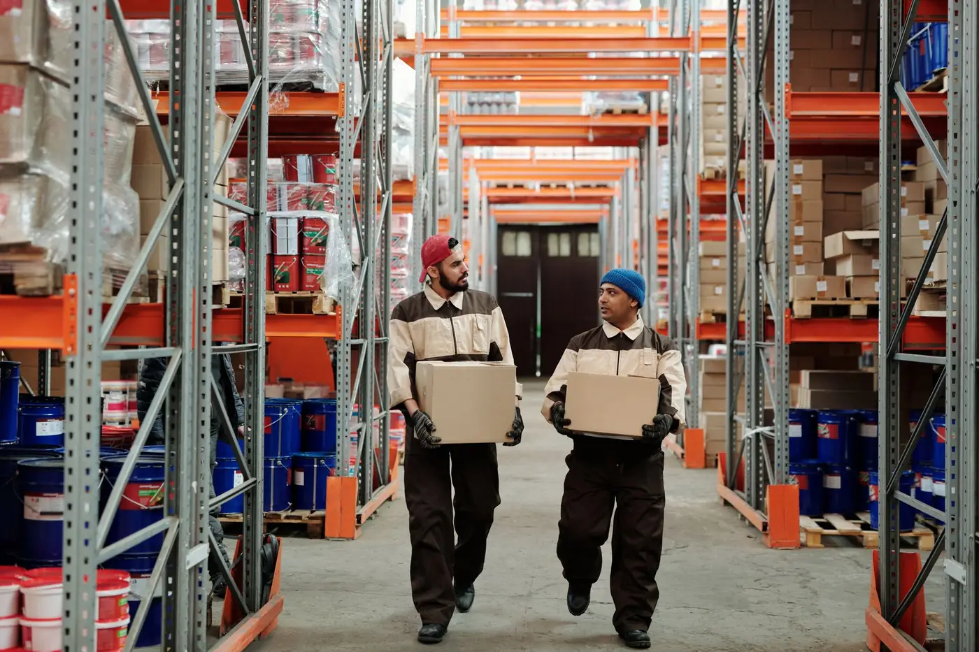 Equipo logístico preparando un pedido profesional entre estanterías de un almacén mayorista