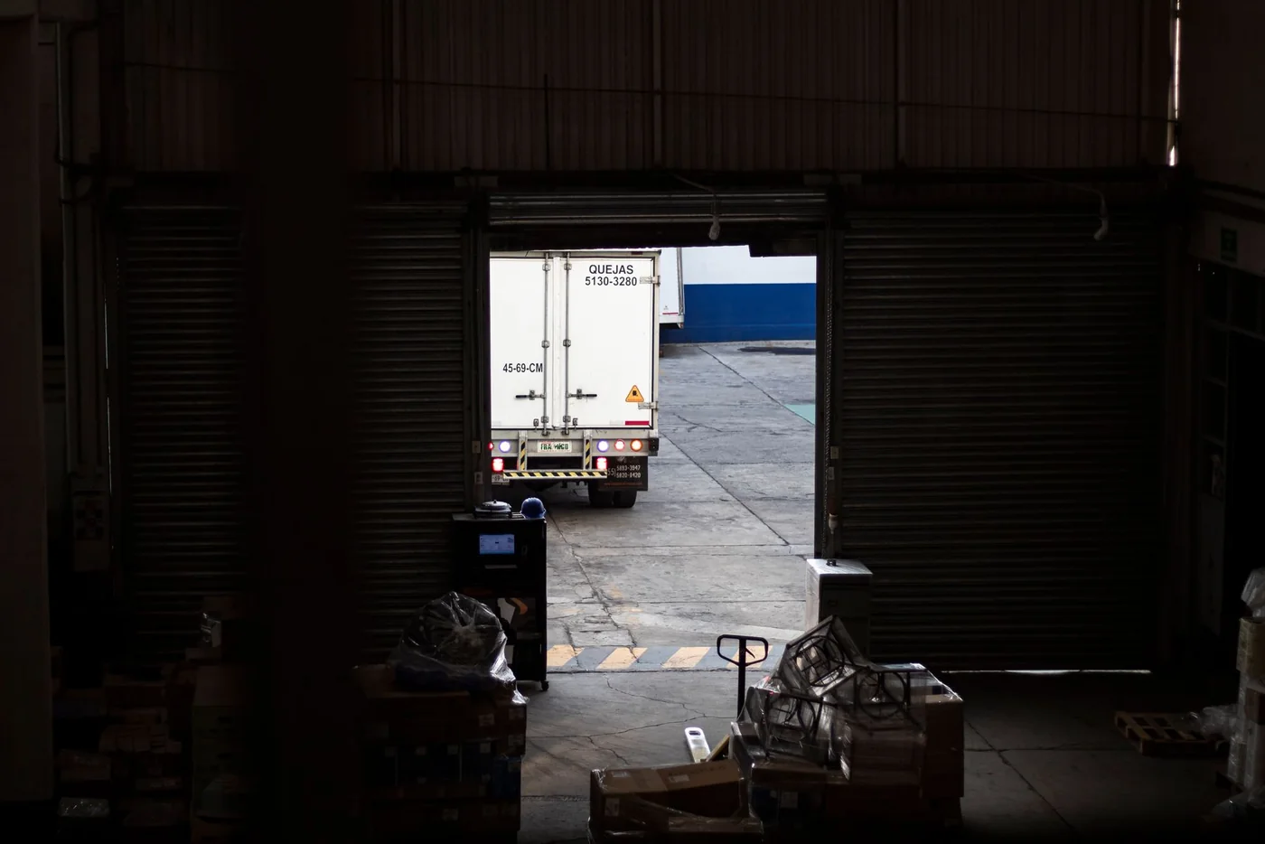 Camión saliendo de un almacén preparado para servir pedidos en otros mercados